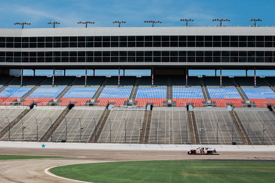 Race car stadium by Jax Facts aerial photography of car on stadium under clear blue sky