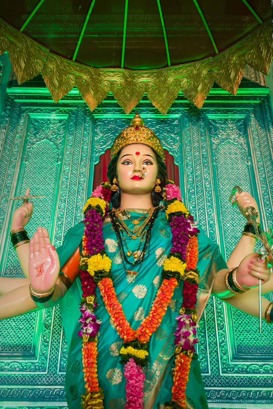 An idol of Maa Durga Devi at a temple in Mumbai, India during Navratri 2019 by Jax Facts woman in purple and yellow floral dress