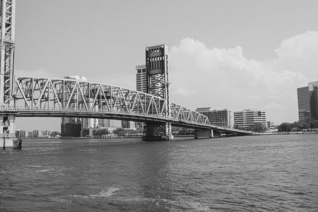 A black and white photo of a bridge over a river
